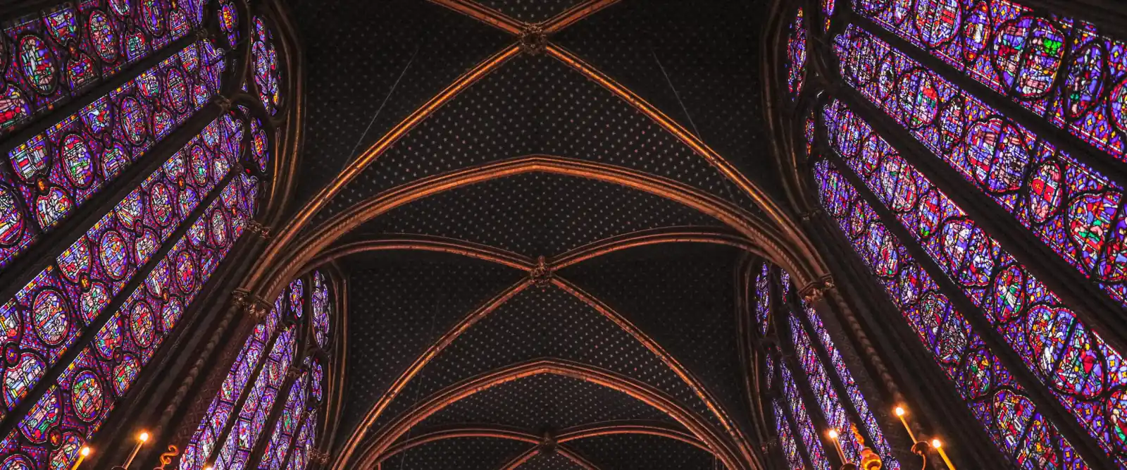 The painted vault of Sainte-Chapelle's upper chapel, ribs springing between walls of stained glass